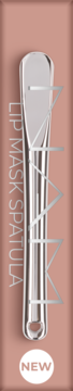 Metalowa szpatułka do maseczki do ust NAM, połyskująca srebrem, na beżowym tle. Etykieta NEW na dole.
