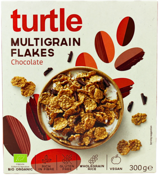 Białe opakowanie płatków Turtle Multigrain Flakes Chocolate 300g, bezglutenowe i wegańskie, miska z płatkami.