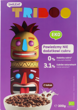 Fioletowe pudełko płatków kakaowych Smileat Triboo EKO bez cukru, z postaciami totemów i miską z mlekiem.