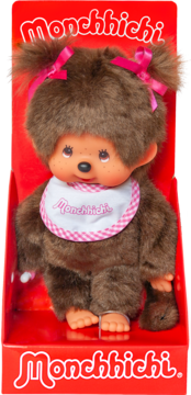 Monchhichi lalka brązowa z różowymi kokardami i białym śliniakiem, zapakowana w czerwone pudełko, widok z przodu.