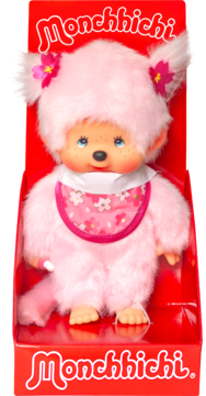 Różowa pluszowa lalka Monchhichi z bibem w kwiaty, uszy z kwiatami, w czerwonym pudełku, widok z przodu.