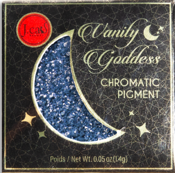 J.cas Vanity Goddess Chromatic Pigment, czarne pudełko z opalizującym niebieskim pigmentem w kształcie księżyca.