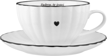 Biała karbowana filiżanka ze spodkiem, z czarnym rantem i sercem, z napisem "Dobre, że jesteś".