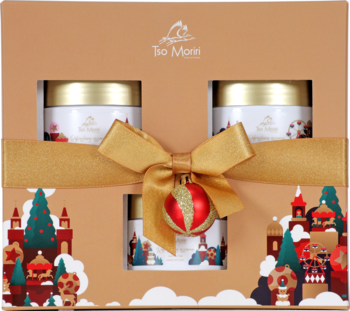 Świąteczny zestaw prezentowy Tso Moriri: złote pudełko z 3 białymi słoiczkami, złotą wstążką i czerwoną bombką.