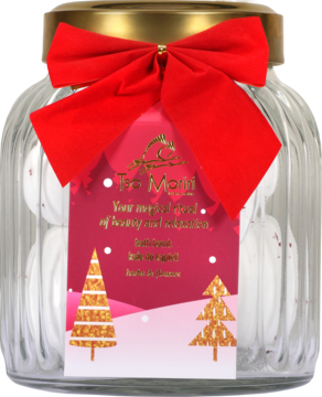 Szklany słoik prezentowy z białymi mochi, przewiązany czerwoną kokardą, z etykietą ze złotymi choinkami.