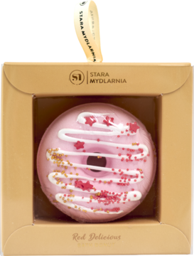 Różowy musujący donut do kąpieli Apple Cake z białym lukrem i posypką, w beżowym pudełku, widok z przodu.