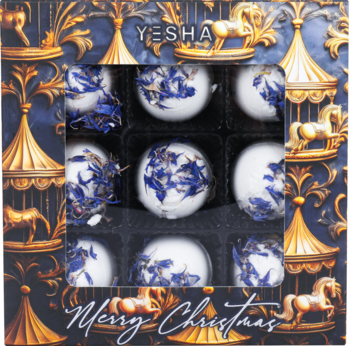 Zestaw 9 wegańskich kul YESHA, magnolia i chaber, w granatowym pudełku świątecznym. Białe kule z płatkami, widok z góry.