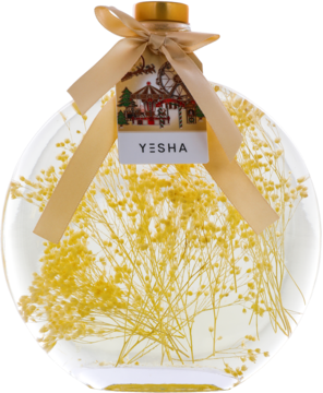 Yesha jaśminowy olejek do kąpieli w przezroczystej butelce z suszonymi żółtymi kwiatami i złotą wstążką, widok z przodu.