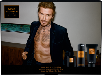 Zestaw David Beckham Bold Instinct: woda perfumowana, dezodorant, żel. Beckham w otwartej marynarce na ciemnym tle.