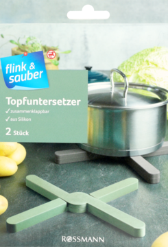 Zielone, składane silikonowe podstawki pod garnek flink & sauber. Jedna używana z garnkiem, druga złożona na tle kuchni.