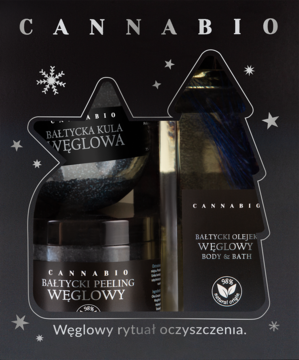 Zestaw prezentowy Cannabio z węglem aktywnym: kula, peeling, olejek, widoczny przez wycięcie choinki w pudełku.