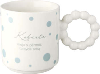 Biały kubek z niebieskimi kropkami i napisem 'Kobieta moja supermoc to bycie sobą', uchwyt z koralików, widok z przodu.
