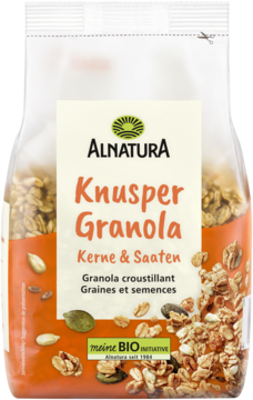 Alnatura Knusper Granola Kerne & Saaten w przezroczystej torbie, widok z przodu. Złocista, chrupiąca.