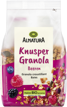 Alnatura Knusper Granola Beeren w białej i różowej torebce, z widocznymi jagodami i płatkami, widok z przodu.