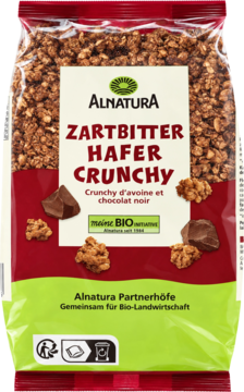 Alnatura Zartbitter Hafer Crunchy, ekologiczne płatki owsiane z gorzką czekoladą, widok z przodu ciemnobrązowej torby.