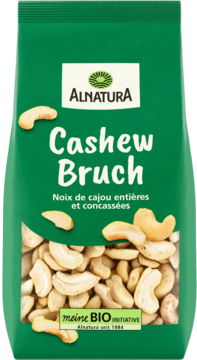 Alnatura Cashew Bruch w zielonej paczce z okienkiem, widać kawałki orzechów nerkowca. Widok z przodu.