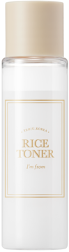 Biała butelka I'm From Rice Toner, kremowy płyn, beżowa zakrętka, złota etykieta z napisem RICE TONER, frontalny widok.