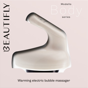 Jasnobeżowy, błyszczący elektryczny masażer bańka Modello Body Beautifly. Ergonomiczny kształt, widok z przodu, na różowym tle.