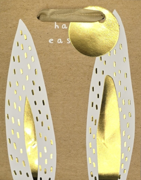 Brązowa torebka prezentowa wielkanocna z białymi uszami królika i złotymi kropkami, napisem 'happy easter'.