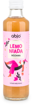 Frontalna butelka abjo LEMONIADA RÓŻANA: bursztynowy napój, różowa etykieta z osobą w hamaku.