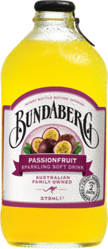 Żółty napój Bundaberg Passionfruit Sparkling Soft Drink w szklanej butelce z kroplami wody, widok z przodu, etykieta z fioletowymi passiflorami.