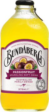 Żółty napój Bundaberg Passionfruit Sparkling Soft Drink w szklanej butelce z kroplami wody, widok z przodu, etykieta z fioletowymi passiflorami.