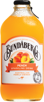 Bundaberg Peach Sparkling Drink w szklanej butelce, widok z przodu. Pomarańczowy napój z brzoskwiniami na etykiecie.