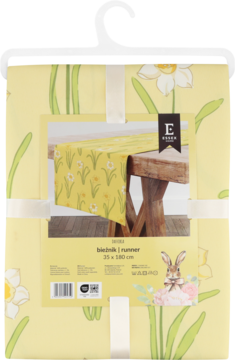 Żółto-biały bieżnik wielkanocny w żonkile na wieszaku, z opakowaniem pokazującym produkt na drewnianym stole.