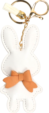 Biały brelok króliczek z pomarańczową kokardą, złotym kółkiem i beżowym chwostem, widok z przodu.