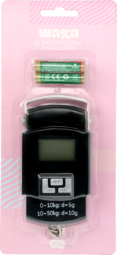 Elektroniczna waga bagażowa w blistrze, czarna z cyfrowym ekranem i dwoma zielonymi bateriami, różowe tło.