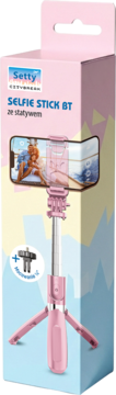 Różowy selfie stick Setty BT ze statywem w pudełku, z zamontowanym smartfonem, widok z przodu.