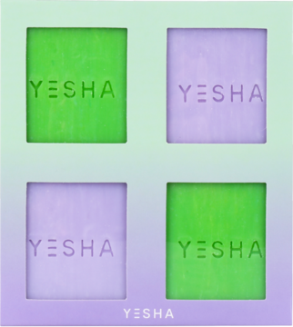 Zestaw czterech kostek mydła Yesha: dwie zielone (werbena) i dwie fioletowe (ananas), w jasnofioletowym opakowaniu.