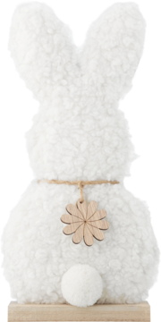Puszysty, biały zając wielkanocny na drewnianej podstawie, z drewnianym kwiatkiem i okrągłym ogonkiem, widok z tyłu.