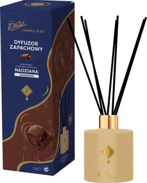 Dyfuzor zapachowy E. Wedel Candly & Co Nadziana deserowa, złota butelka z patyczkami obok pudełka czekolady.
