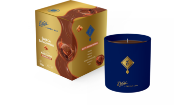 Granatowa świeca zapachowa Czekolada Nadziana Karmelowa 150g, obok złote opakowanie gorącej czekolady.