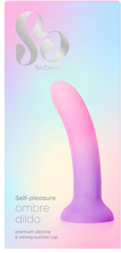 Opakowanie silikonowego dilda ombre So Divine. Ma różowo-fioletowy gradient, zakrzywiony kształt i przyssawkę. Widok z przodu na pastelowym tle.