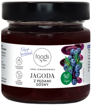 Słoik Foods by Anna Jagoda z pędami sosny. Ciemnofioletowa zawartość, biała etykieta z borówkami i logo Vegan, widok z przodu.