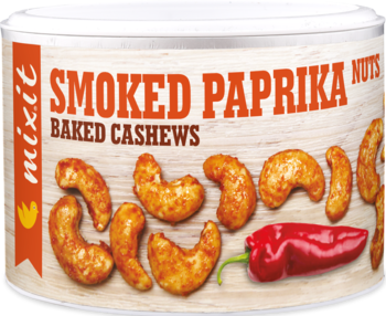 mixit Smoked Paprika Baked Cashews. Biała tuba z orzechami i papryką, drewniane tło, widok z przodu.
