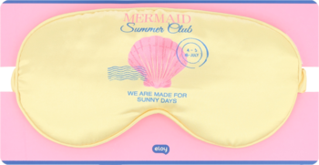 Eloy maska na oczy, jasnożółta z różową muszelką i napisem 'MERMAID Summer Club', leży na różowym opakowaniu.