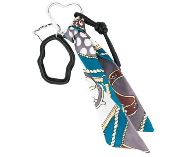 Brelok Eloy wzór4: metalowy karabińczyk, czarna pętla i złożona apaszka w niebiesko-szaro-białe wzory żeglarskie.