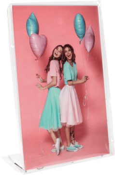 Akrylowy panel ze zdjęciem dwóch uśmiechniętych kobiet w pastelowych ubraniach, z balonami, widoczny pod kątem.