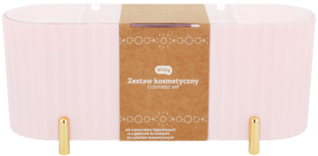 Różowy zestaw kosmetyczny w podłużnym pudełku, z brązowo-złotą etykietą i nóżkami, widok z przodu.