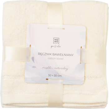 Kremowy ręcznik bawełniany 30x30 cm, złożony i przewiązany ozdobną wstążką z etykietą, widok z góry.