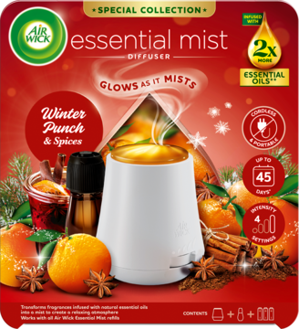 Air Wick Essential Mist Diffuser Winter Punch & Spices, biały, z mgiełką i blaskiem, na tle z pomarańczami i korą cynamonu.