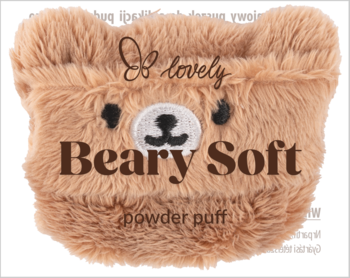 Puszysty, beżowy puszek do pudru w kształcie misia z haftowanymi oczami i nosem, napisem 'Beary Soft', widok z przodu.