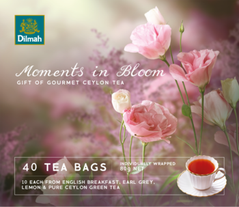 Dilmah Moments in Bloom, herbata 40 torebek, kwiatowe opakowanie, filiżanka herbaty na tle rozmytych różowych kwiatów.