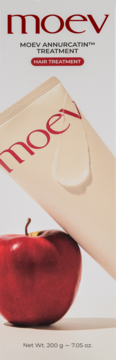 MOEV ANNURCATIN™ hair treatment w beżowej tubce, z kropelką produktu i czerwonym jabłkiem na pierwszym planie.