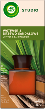 Air Wick Studio opakowanie dyfuzora trzcinowego Vetiver & Sandalwood. Bursztynowa butelka na tle liści.