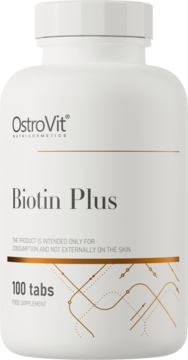 Biała butelka suplementu OstroVit Biotin Plus, 100 tabletek, widok z przodu z złotymi akcentami na etykiecie.