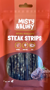 Front pomarańczowej torebki Misty & Bluey Steak Strips dla psa, z widocznymi bezzbożowymi paskami mięsa.
